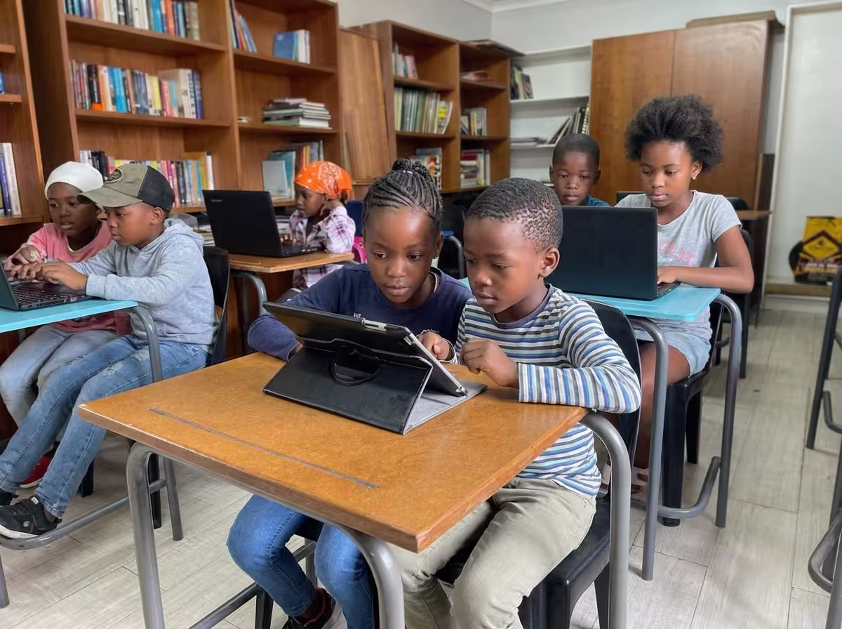 Diepsloot children learning on laptops and tablets
